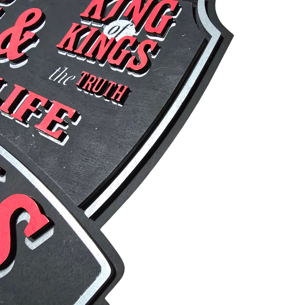 Close-up of the layered craftsmanship on the King of Kings Shield Sign, showcasing dimensional lettering, painted details, and precision laser-cut wood construction.